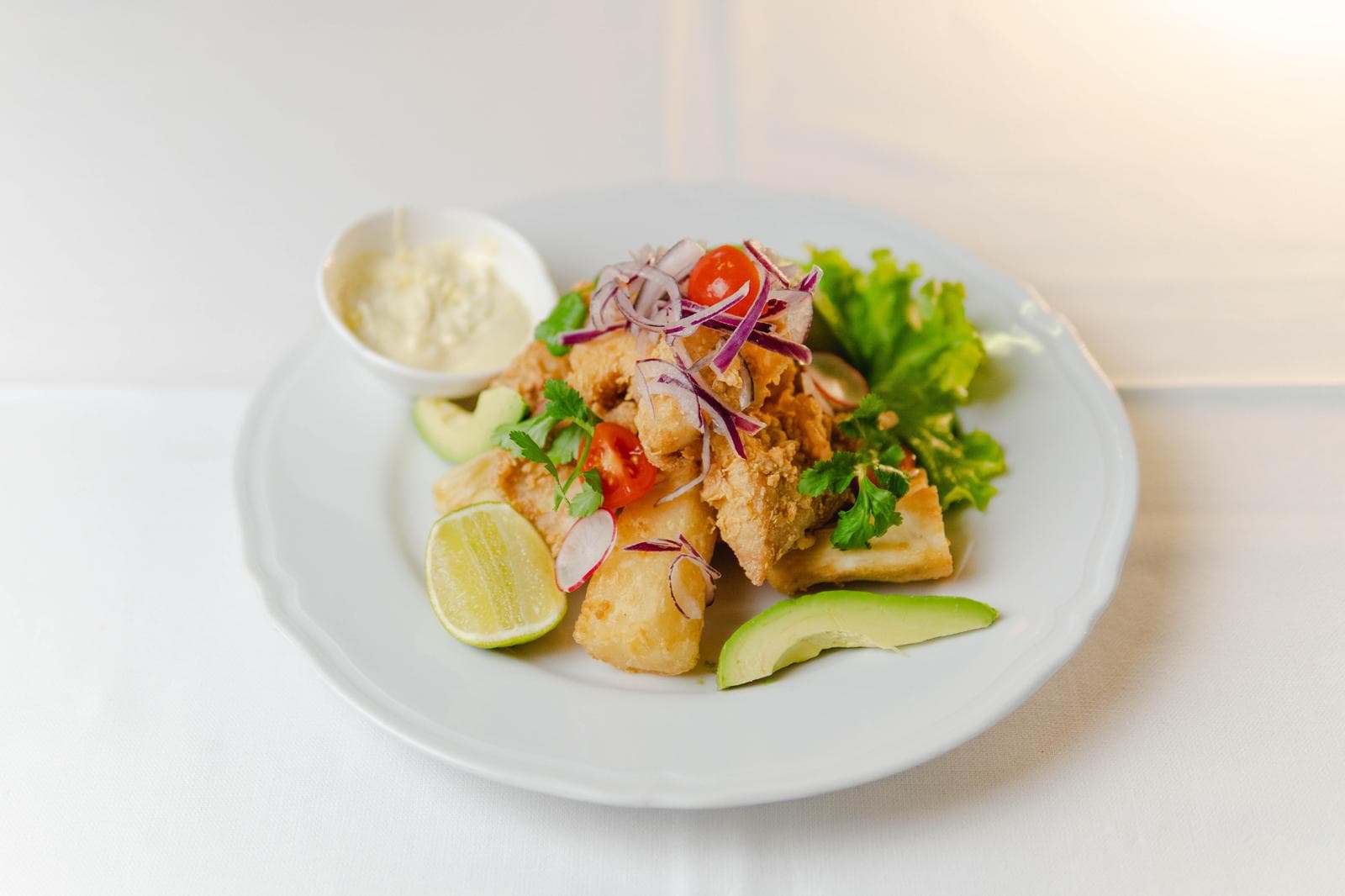 Fried fish with salsa criolla, lime and avocado